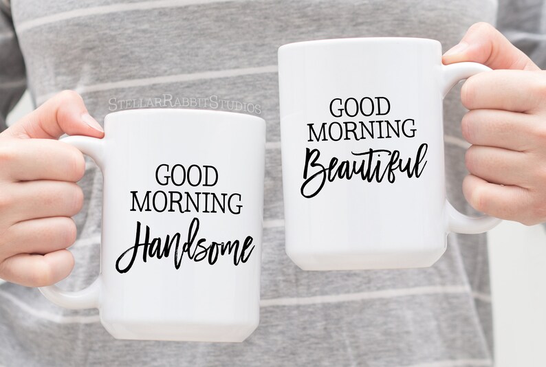 Peut inclure: Deux tasses en c&eacute;ramique blanche avec du texte noir. Une tasse dit "Good Morning Handsome" et l'autre tasse dit "Good Morning Beautiful".