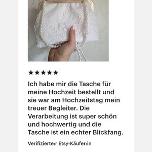 May include: A white bridal clutch with a gold clasp and a pearl strap. The clutch is adorned with delicate floral lace. The text in the image says, "Ich habe mir die Tasche f&uuml;r meine Hochzeit bestellt und sie war am Hochzeitstag mein treuer Begleiter."