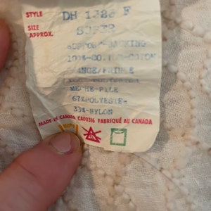May include: White fabric label with blue and red text. The label reads "STYLE DH 1728 F SUPER", "OPG-KING 100%-CO. 100%-COTON RANGE/FRIME", "MECHE-PILE 67% POLYESTER 33%-NYLON", "MADE IN CANADA CA00316 FABRIQU&Eacute; AU CANADA".
