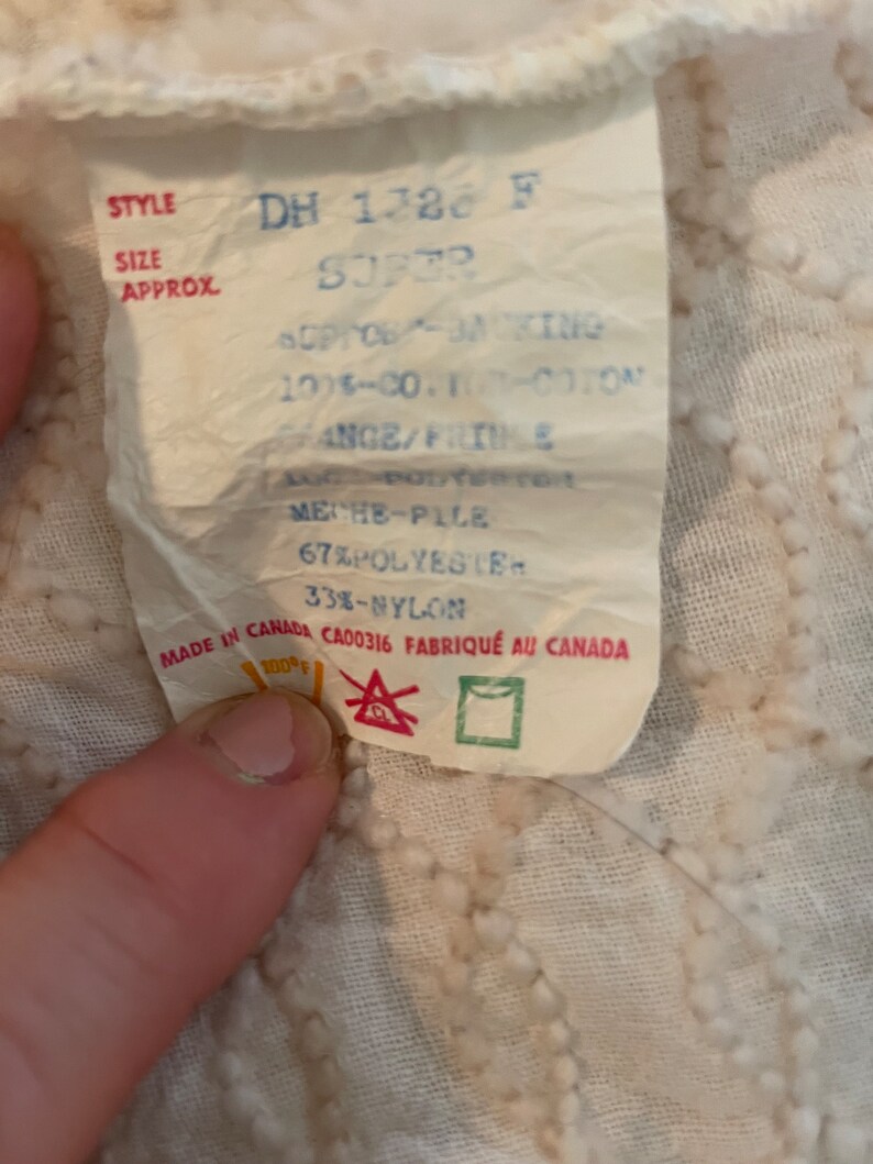 May include: White fabric label with blue and red text. The label reads "STYLE DH 1728 F SUPER", "OPG-KING 100%-CO. 100%-COTON RANGE/FRIME", "MECHE-PILE 67% POLYESTER 33%-NYLON", "MADE IN CANADA CA00316 FABRIQU&Eacute; AU CANADA".