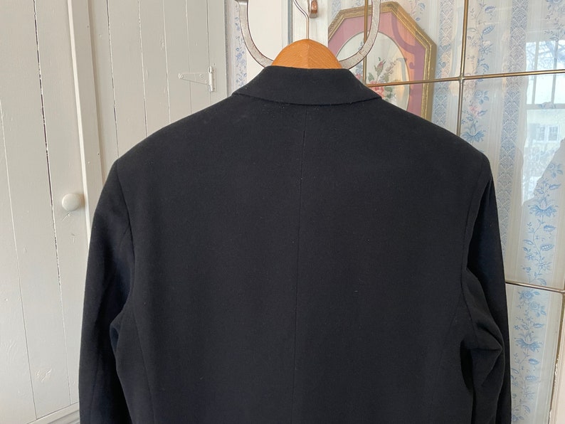 Puede incluir: Una chaqueta negra de dise&ntilde;o cl&aacute;sico. La chaqueta tiene cierre de un solo bot&oacute;n y solapa de muesca.