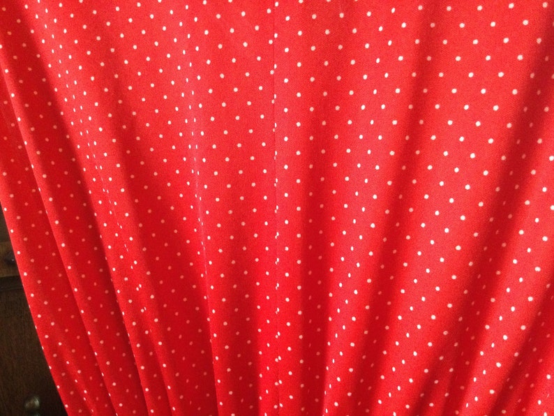 May include: Red fabric with a white polka dot pattern.