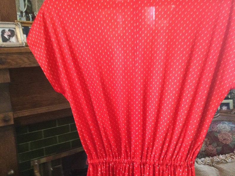 May include: A red dress with a white polka dot pattern. The dress has a gathered waist and short sleeves.