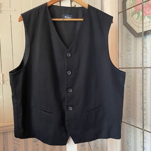 May include: A black sleeveless waistcoat with a V-neck and five buttons down the front. The waistcoat has two pockets on the front and a label that says "BOSA" on the inside.