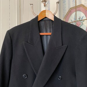 Puede incluir: Una chaqueta negra de doble botonadura con un corte cl&aacute;sico y dos botones. La chaqueta est&aacute; hecha de una tela suave y de alta calidad.