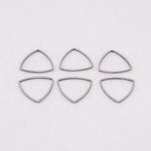 May include: Six silver triangle jump rings, each with a smooth, rounded edge.
