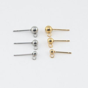 May include: Three pairs of earring findings with a small loop at the bottom. The findings are made of metal and come in silver and gold.