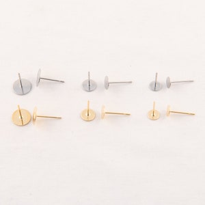 May include: Six earring posts in two colors: silver and gold. Each post has a flat, round pad for attaching earrings. The posts are straight and have a simple, minimalist design, perfect for DIY jewelry making.