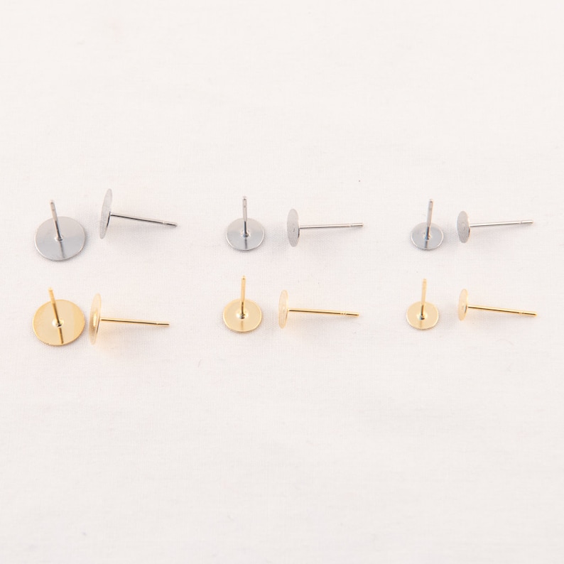 May include: Six earring posts in two colors: silver and gold. Each post has a flat, round pad for attaching earrings. The posts are straight and have a simple, minimalist design, perfect for DIY jewelry making.