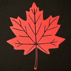 May include: A bright red maple leaf with a black outline. The leaf is on a black background.