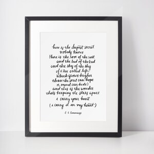 May include: Black and white framed print of a poem by E.E. Cummings. The poem is titled "here is the deepest secret" and includes the lines "i carry your heart" and "i carry it in my heart".
