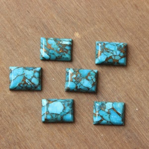 May include: Six turquoise cabochons with gold flecks. The cabochons are rectangular and have a smooth, polished surface.