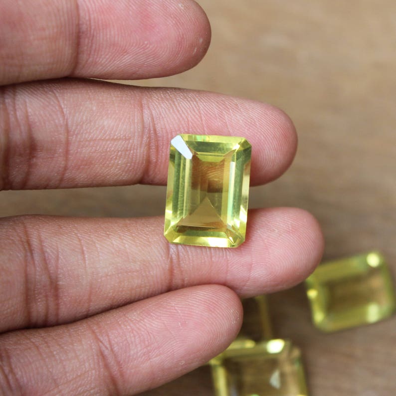 K&ouml;nnte beinhalten: Eine Sammlung von f&uuml;nf gelben Citrin-Edelsteinen, die in Smaragdform geschliffen sind. Die Edelsteine sind facettiert und haben eine durchscheinende Optik.