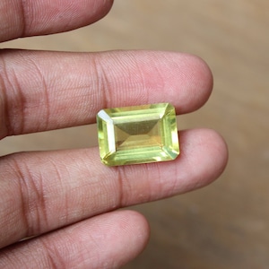 May include: A light green gemstone with a rectangular cut and a smooth, polished finish.