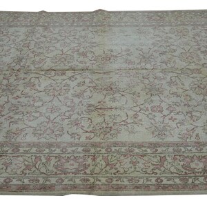 May include: A large, rectangular rug with an intricate floral pattern in shades of cream, pink, and brown. The rug features a detailed border with floral motifs. The overall design is vintage and adds a touch of elegance.