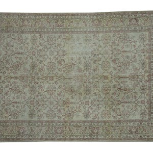 May include: Rectangular area rug with a floral pattern in shades of beige, light green, and muted red. The rug features a detailed border and an overall distressed appearance, suggesting a vintage style.