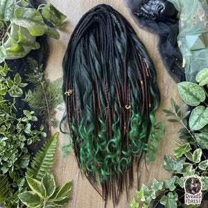 May include: A set of synthetic dreadlocks featuring a blend of dark brown and deep forest green strands. The hair extensions include wavy textures, braided sections, and small gold-toned metal charms attached to individual locks.