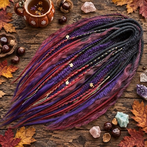 May include: A set of synthetic hair extensions featuring a mix of deep purple, burgundy, and black dreadlocks and loose wavy strands. The hair is adorned with small gold-colored leaf charms and decorative thread wraps, creating a textured appearance.