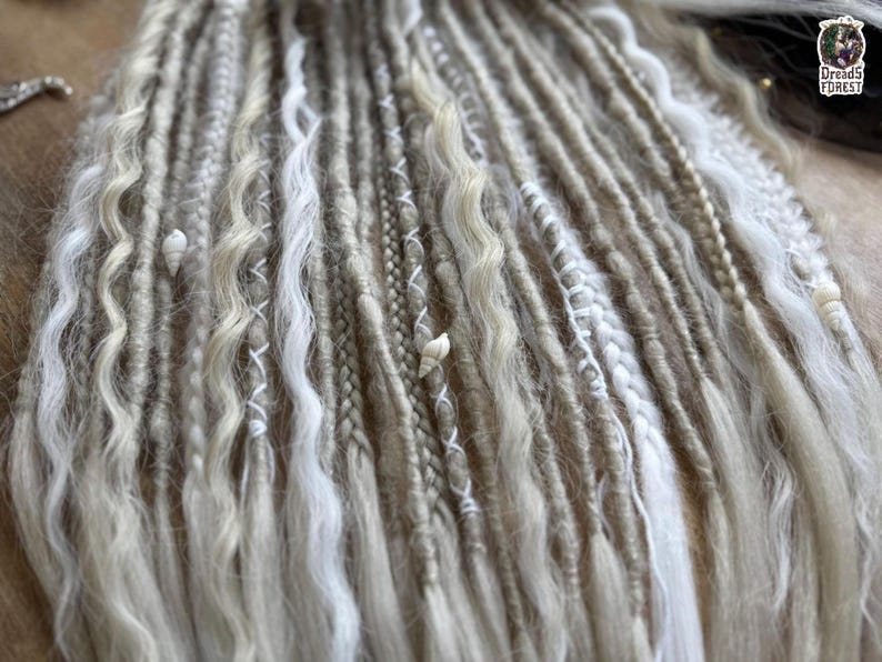 a close-up view of various braided and twisted hair strands in different shades of white and gray.
