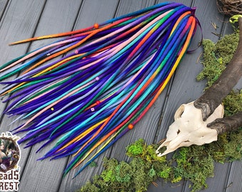 May include: A set of colorful wool dreadlocks with beads. The dreadlocks are arranged in a fan shape on a wooden surface.