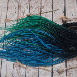 a collection of colorful hair dyes in blue, green, and black, arranged on a wooden surface.