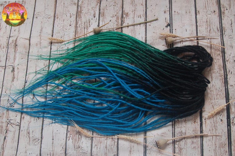 a collection of colorful hair dyes in blue, green, and black, arranged on a wooden surface.