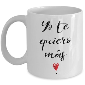 Peut inclure: Mug en c&eacute;ramique blanche avec une anse incurv&eacute;e. Le mug porte l'inscription "Yo te quiero m&aacute;s" en &eacute;criture noire, avec un petit c&oelig;ur rouge en dessous. Con&ccedil;u pour les boissons chaudes.
