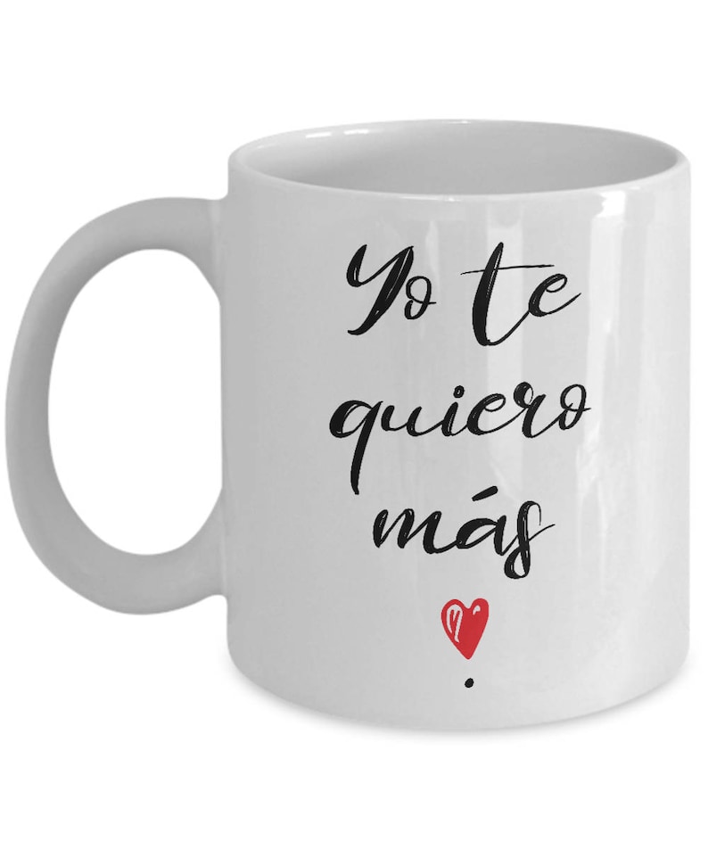 Peut inclure: Mug en c&eacute;ramique blanche avec une anse incurv&eacute;e. Le mug porte l'inscription "Yo te quiero m&aacute;s" en &eacute;criture noire, avec un petit c&oelig;ur rouge en dessous. Con&ccedil;u pour les boissons chaudes.