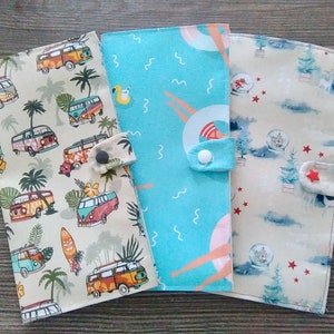 May include: Three fabric zippered pouches with different patterns. The first pouch has a light beige background with a pattern of palm trees and vintage vans. The second pouch is light blue with a wavy pattern and a pink sun. The third pouch has a light beige background with a pattern of snowmen and Christmas trees.