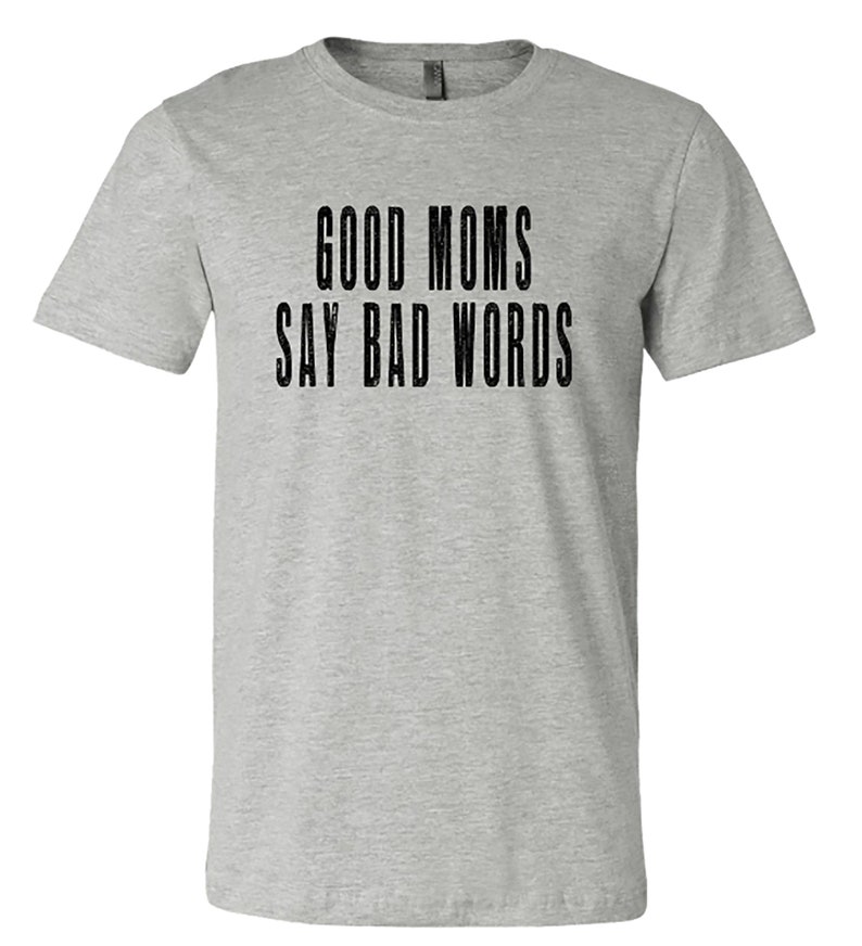 May include: A heather grey t-shirt with the text "GOOD MOMS SAY BAD WORDS" printed in black.