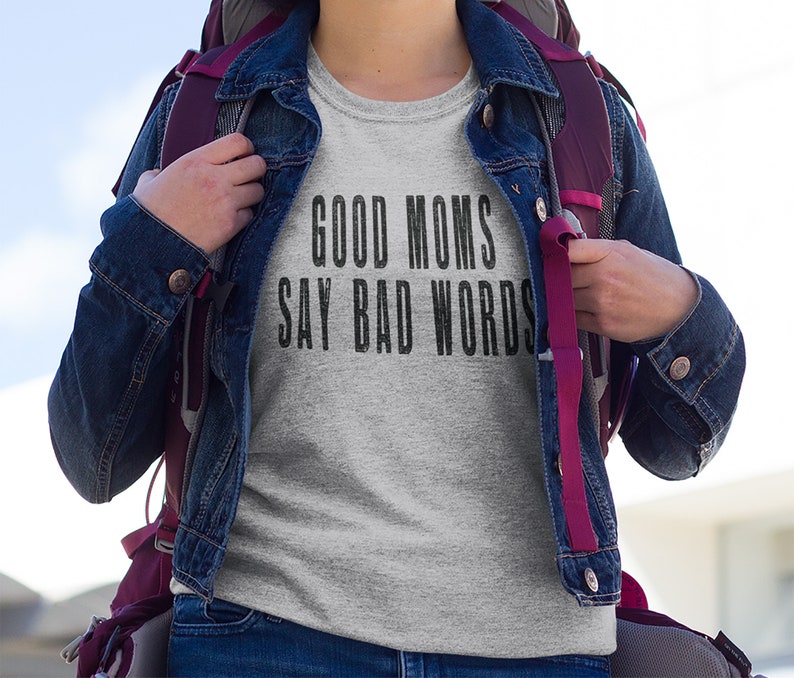 May include: A grey t-shirt with the text "GOOD MOMS SAY BAD WORDS" printed in black.