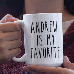 May include: White ceramic mug with black text that reads "Andrew is my favorite".