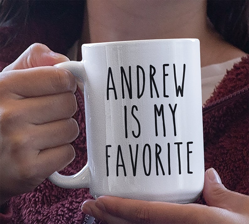 May include: White ceramic mug with black text that reads "Andrew is my favorite".