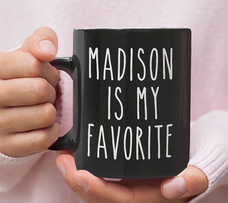 May include: Black coffee mug with white text that reads "MADISON IS MY FAVORITE".