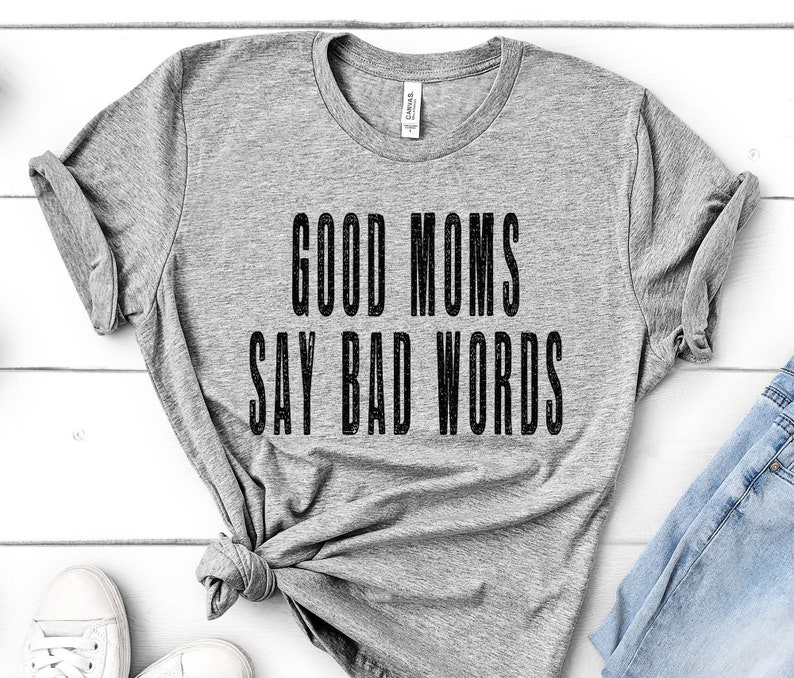 May include: Grey t-shirt with the text "Good Moms Say Bad Words" printed in black.