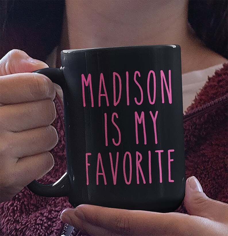 May include: Black coffee mug with the text "MADISON IS MY FAVORITE" in pink lettering.