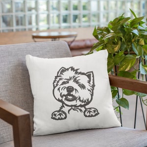 K&ouml;nnte beinhalten: Ein wei&szlig;es Kissen mit einem schwarzen und wei&szlig;en gestickten Bild eines Westie-Hundes, der &uuml;ber die Oberseite des Kissens schaut.