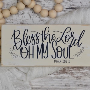 May include: A white wooden sign with black calligraphy that reads "Bless the Lord Oh My Soul" and "Psalm 103:1".