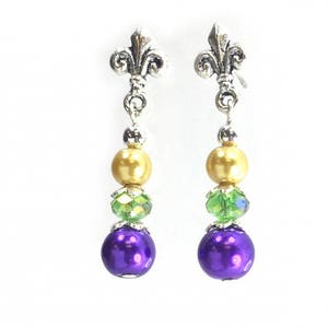 May include: Purple, green and gold bead earrings with a silver fleur-de-lis charm.