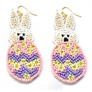 May include: A pair of Easter-themed earrings. Each earring features a beaded bunny design with a white head, black eyes, and a colorful egg-shaped body in pink, yellow, and purple. The earrings have gold-colored hooks.
