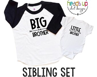 Puede incluir: Una camiseta blanca y negra de estilo raglán con las palabras "BIG BROTHER" y un diseño de flecha. También se muestra un body blanco con el texto "LITTLE BROTHER". La imagen también incluye el texto "SIBLING SET AVAILABLE IN MANY SIZES".