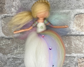 May include: A handmade felt fairy doll with a rainbow skirt and long blonde hair. The doll is decorated with iridescent sequins.