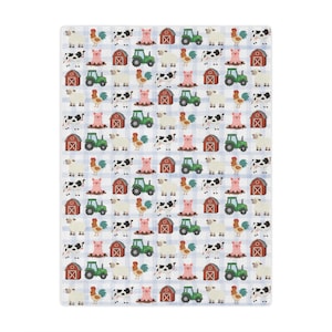 May include: A white blanket featuring a repeating pattern of farm animals, such as cows, pigs, sheep, and roosters, alongside green tractors and red barns. The background has a light blue checked design.