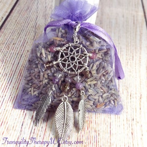 May include: A purple lavender sachet with a silver dreamcatcher charm and feathers. The sachet is tied with a purple ribbon and has the text "Tranquility Therapy UK Etsy.com" on the bottom.