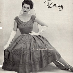 Könnte beinhalten: Schwarzweißfoto einer Frau in einem gestrickten Kleid mit einem Botany-Etikett. Das Kleid hat ein tailliertes Oberteil und einen vollen Rock. Die Frau trägt weiße Handschuhe und hohe Schuhe.