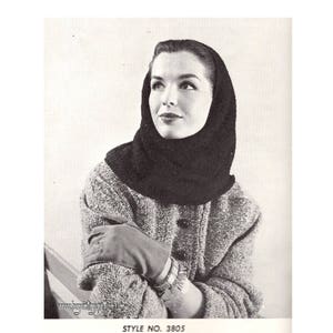 May include: Black and white photo of a woman wearing a black knit hooded scarf. The scarf is worn over her head and covers her neck and shoulders. She is wearing a tweed jacket and has her arms crossed. The photo is from a vintage knitting pattern.