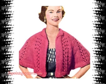 May include: A pink knitted cardigan with a lace pattern. The cardigan has a collar and short sleeves. The model is wearing a black and white polka dot dress underneath.