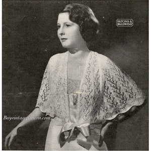 May include: A black and white photograph of a woman wearing a white crocheted shawl with a delicate lace pattern. The shawl is tied at the waist with a bow. The woman is wearing a white dress and has her hair styled in a short bob. The photo is from the 1930s and features the text "Patons & Baldwins" in a small rectangle at the top right corner.