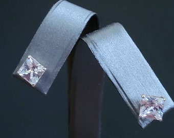 May include: A pair of silver stud earrings with square-shaped clear gemstones.
