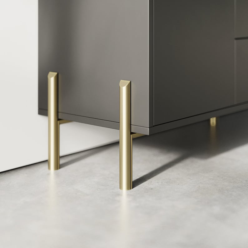 May include: A dark gray cabinet with gold metal legs. The cabinet has a simple design and is made of wood.